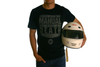 Front view of model wearing Give Me Manual tee. Tee is black with grey text. Model is holding a white racing helmet.